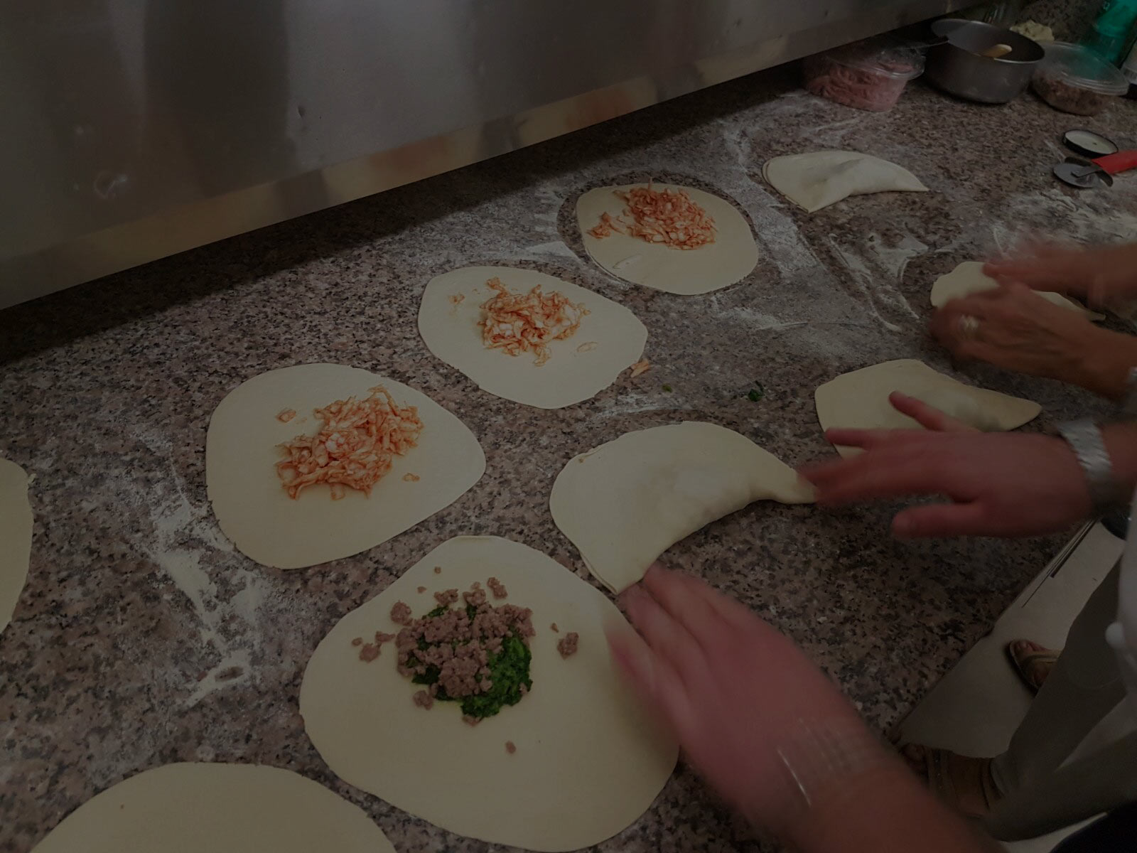 Preparazione a mano dei panzerotti baresi sul banco di lavoro di Panzeropoli