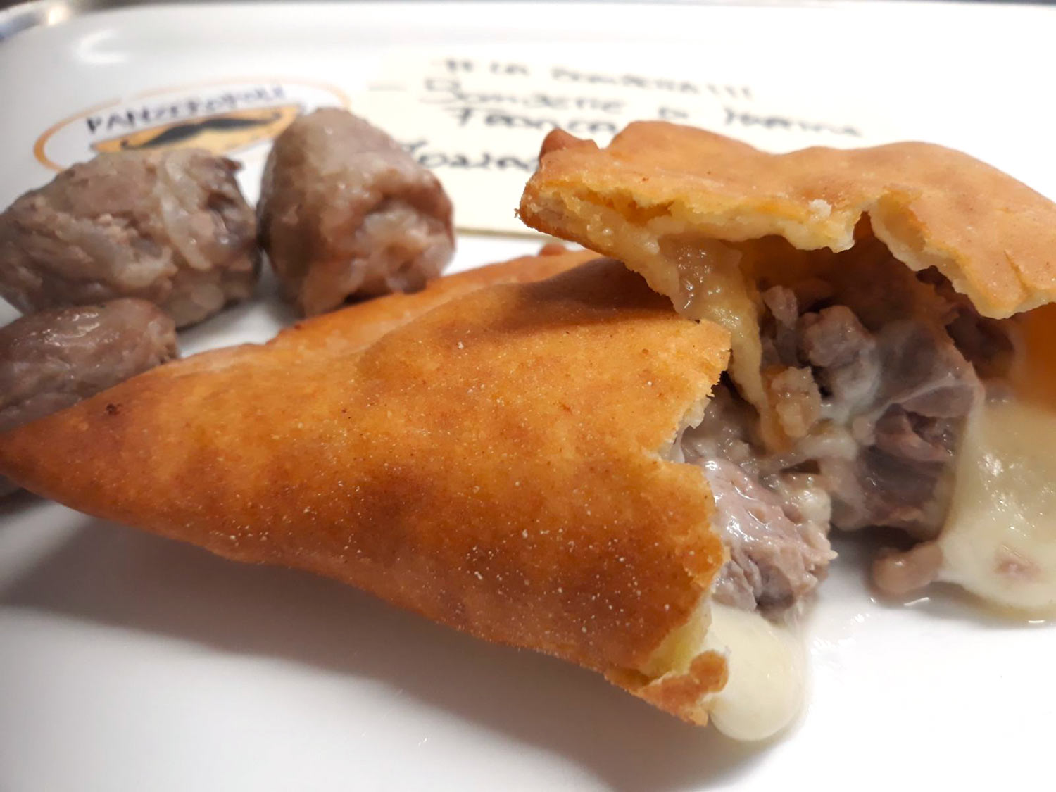 Panzerotto fritto aperto con ripieno filante di carne e formaggio da Panzeropoli Bari