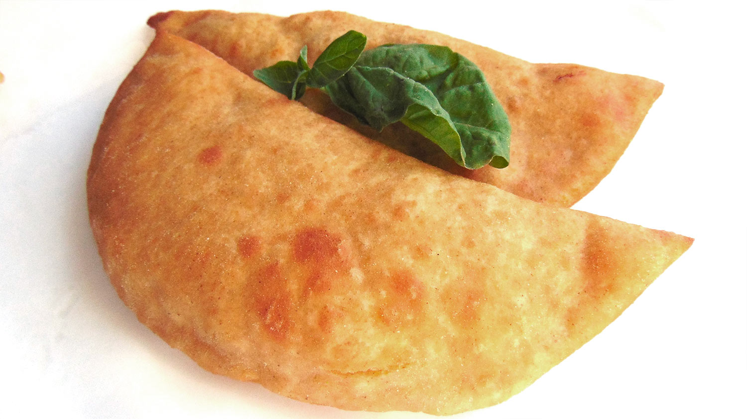 Due panzerotti vegani dorati con basilico fresco della linea VegUp di Panzeropoli Bari